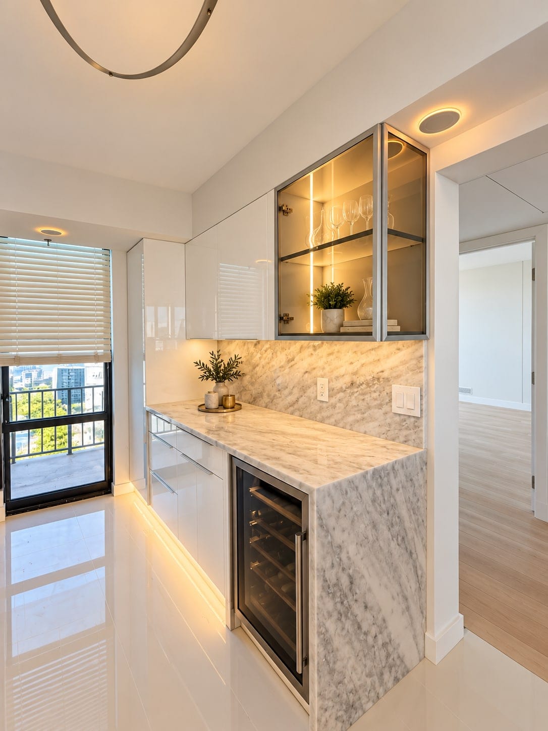 Wet bar with a lit glass wall cabinet and white gloss base units