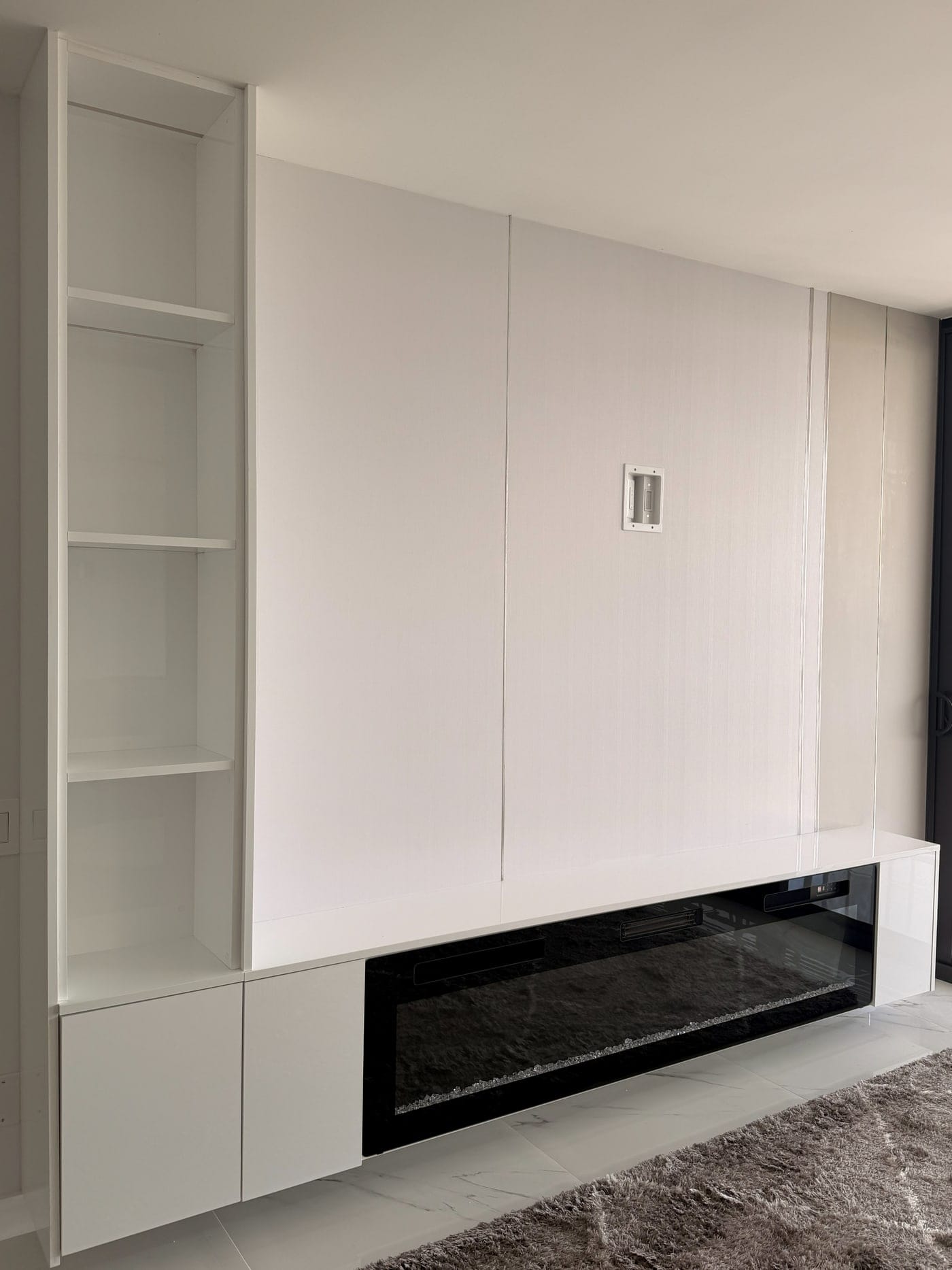 White wall unit with open shelving around a fireplace