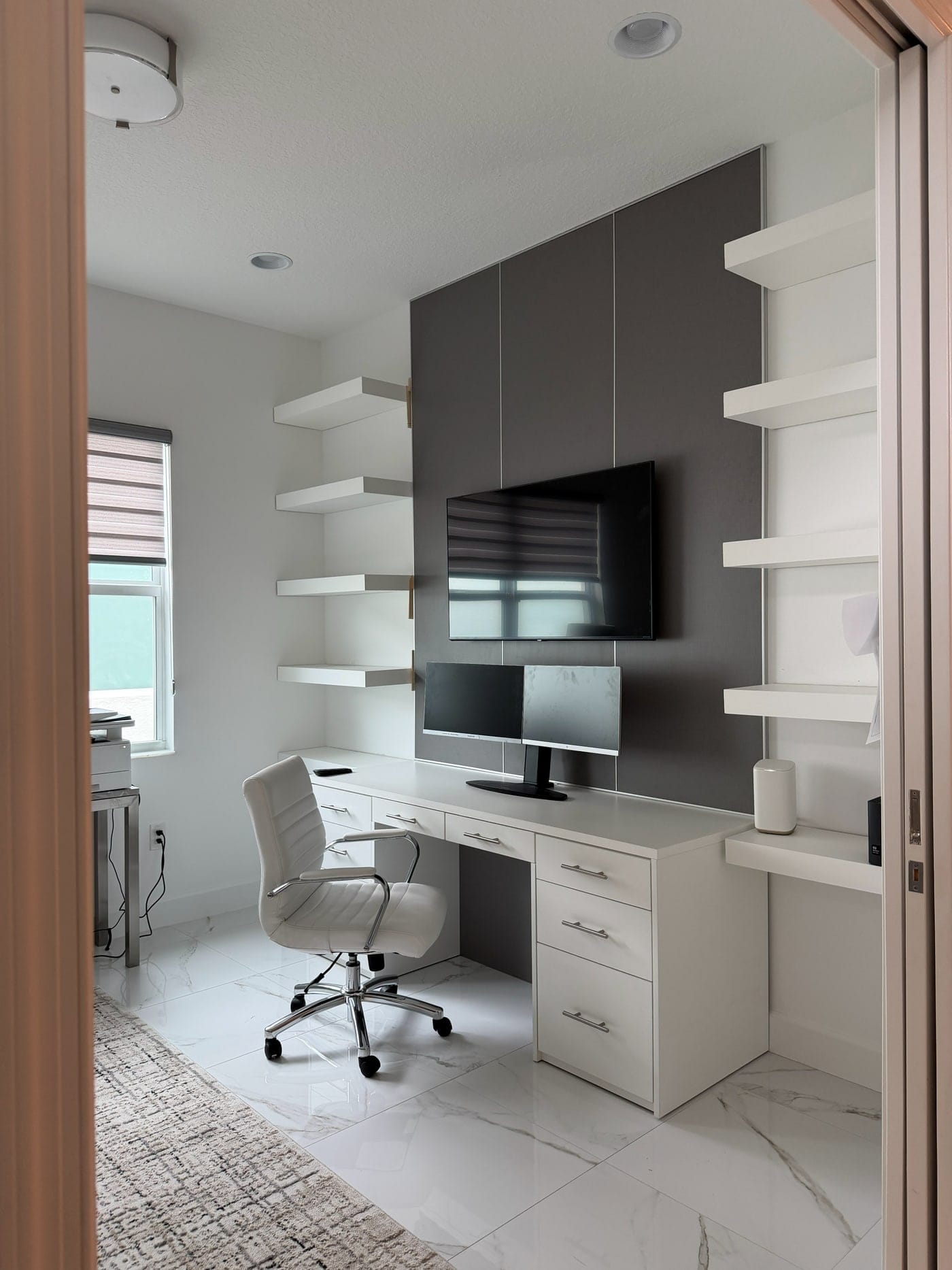 Home office wall unit with a built-in desk and floating shelves